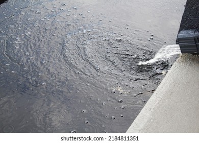 Rain Water Running From Downspout Drain Gutter In Parking Lot,selective Focus