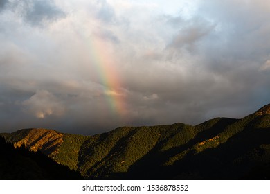 Rainbow above a mountain range during late sunset