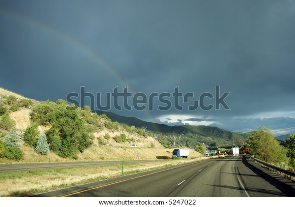 Rainbow\
after storm above interstate highway,\
Colorado