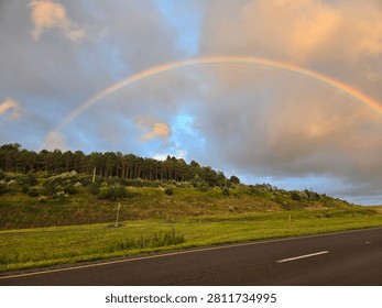 A rainbow arcing over a highway