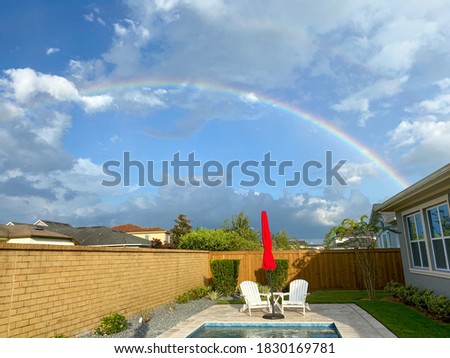 A rainbow in a backyard with a pool in Orlando, Florida.