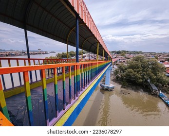 Rainbow bridge in Kuala Perlis. View of the colorful metal bridge extends across the fishing village. Selective focus. - Shutterstock ID 2236078297