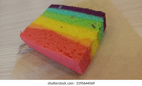 Rainbow Cake, On A Brown Paper Napkin.