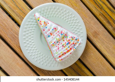 Rainbow cake in white dish on the wood table