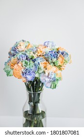 Rainbow Carnations On A White Background In A Transparent Vase