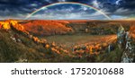 Rainbow with clouds over a rock