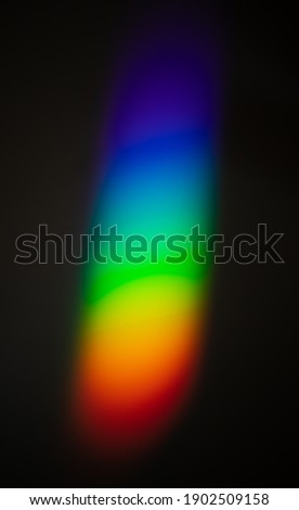 Rainbow color spectrum effect on wall, light scatter after hitting the glass object on to a dark wall.