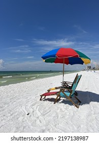 Rainbow Colored Beach Umbrella And Lounge Chairs On Florida White Sand Beach