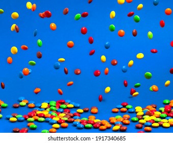 Rainbow Colored Candy Coated Chocolate Buttons Falling into a Pile - Powered by Shutterstock