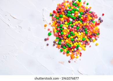 Rainbow colored candy nerds sprinkled on a white background. - Shutterstock ID 1961076877