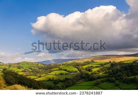 A rainbow and dramatic countryside view from Carrag Cennen castle located on top of a rocky hill in Carmarthenshire Wales UK