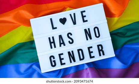 Rainbow flag with lightbox and text LOVE HAS NO GENDER. Rainbow lgbtq flag made from silk material. Symbol of LGBTQ pride month. Equal rights. Peace and freedom. Support LGBTQ community