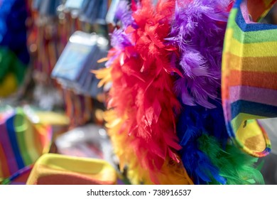 Rainbow Flag Merchandise Including Feather Boa, Hats, And Other Colourful Symbolic Items On A Stall At A LGBT Festival In The UK