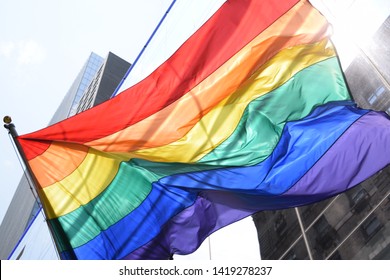 Rainbow Flag On New Building Facing An Old Building. Pride Month In Big City