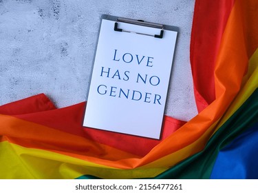 Rainbow flag with text LOVE HAS NO GENDER message paper note. Rainbow lgbtq flag made from silk material. Symbol of LGBTQ pride month. Equal rights