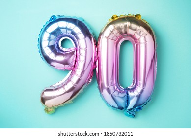 Rainbow foil balloon number, digit ninety. Birthday greeting card with inscription 90. Anniversary concept. Top view. Colored numeral on blue background. Numerical digit, Celebration event, template. - Shutterstock ID 1850732011