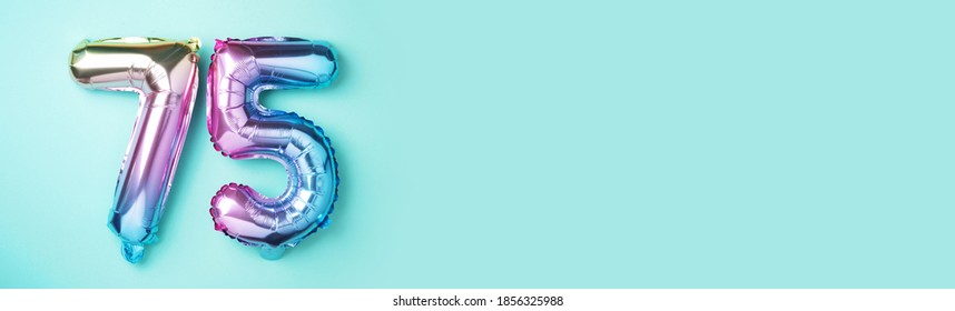 Rainbow foil balloon number, digit seventy-five. Birthday greeting card with inscription 75. Anniversary concept. Top view. Colored numeral on blue background. Numerical digit, Celebration event. - Shutterstock ID 1856325988