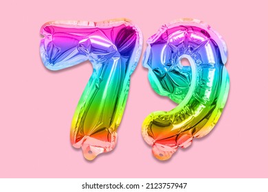 Rainbow foil balloon number, digit seventy nine on a pink background. Birthday greeting card with inscription 79. Top view. Numerical digit. Celebration event, template.