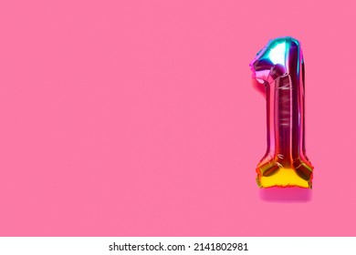 Rainbow Foil Balloon Number, Digit One. Top View. Colored Numeral On Pink Background.