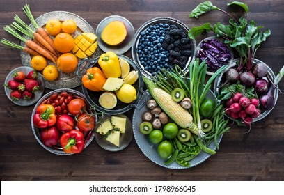 Rainbow Fruit And Vegetable Flat Lay Arrangement Against A Dark Wooden Background.