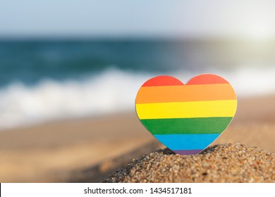 Rainbow Gay Flag Heart On The Beach. LGBT Concept.  LGBT Equal Rights Movement And Gender Equality Concept. Copy Space. Romantic Trip Gay Honeymoon 