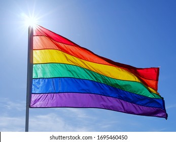 Rainbow Gay Pride Flag On Blue Sky  With White Clouds Background, Miami Beach, Florida, USA