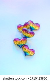 rainbow glitter hearts on blue background close up. colorful small shiny hearts, symbol of love. Valentine's Day, 14 february, romantic date concept