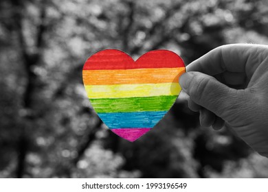 Rainbow Heart In A Woman's Hand On Black And White Background. Human And LGBTQ Rights Concept, Fight Against Discrimination Because Of Sexual Orientation.