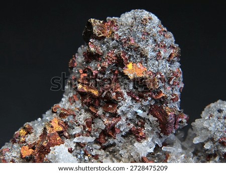 Rainbow iridescent chunks of the copper containing mineral bornite with colourless hexagonal crystals of quartz 