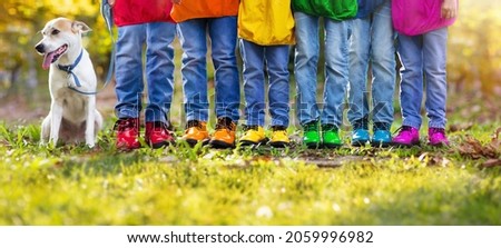 Rainbow kids shoes. Children and dog play outdoor in sunny autumn park. Hiking footwear for fall walk fun. Active child clothing and warm boots. Rain weather wear. Boy and girl fashion.