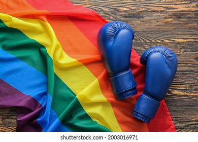 Rainbow LGBT Flag And Boxing Gloves On Wooden Background