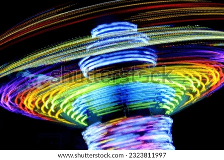 A rainbow of lights swirling around, showing energy and motion at an amusement park SSTKabstract
