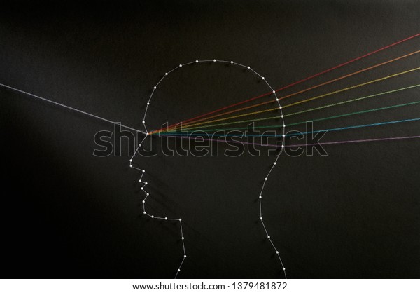 Rainbow mind\
concept. Network of pins and threads in the shape of a ray of light\
going through a persons head symbolising that the mind is a prism\
and thoughts are a refraction\
process.