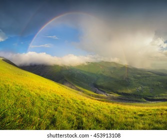 Rainbow in mountain valley during sunset. Beautiful natural landscape - Shutterstock ID 453913108
