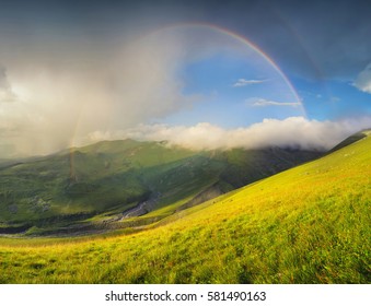 Rainbow in mountain valley during sunset. Beautiful natural landscape - Shutterstock ID 581490163