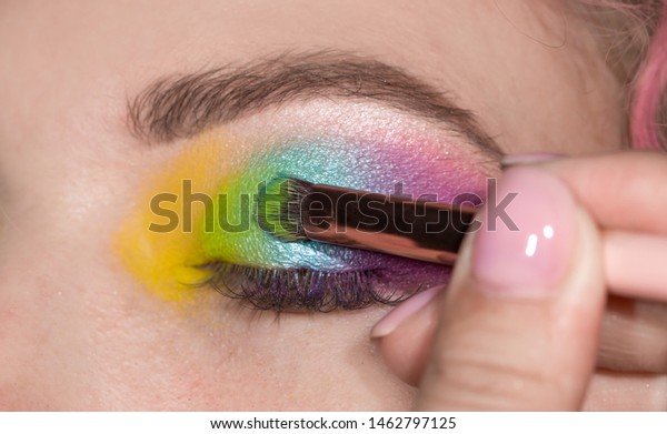 パーティーやディスコの虹の多彩色のアイメイク まぶたに多彩色の影を付けた閉じた目 プロの色合いの女の子 Lgbtの動きの旗の色 舞台化粧 の写真素材 今すぐ編集