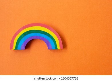 Rainbow Object, Over Orange Background. LGBT Concept. Education Background With Copy Space For Text.