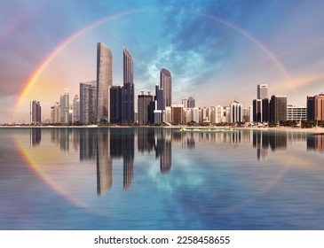 Rainbow over Abu Dhabi skyline with reflection in sea, United Arab Emirates - panorama - Powered by Shutterstock