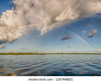 Rainbow Over The Amazon River During Sunny And Cloudy Day. Iquitos, Peru, Latin America.