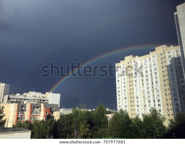 Rainbow over the city. Rainbow in the city. Rainy\
weather on a city street. rain in city,rain drops Rain season. .\
Double Rainbow over the city on Rainy day. Double Rainbow in the\
town in Heavy rain 