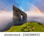 Rainbow over coast cliff in ocean Drangarnir in Faroe island. Sunset landscape