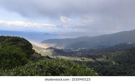 Rainbow over Elba Island Italy mist-covered sea mountains ancient Livorno village nestled in greenery. Misty atmosphere after rain scenic tropical mountainous views tropical landscape cloudy day - Powered by Shutterstock