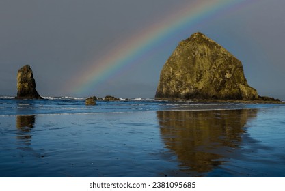 A rainbow over Haystack Rock and a Needle at Canon Beach on the north Oregon coast