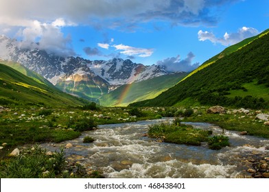 Rainbow over the rapid river and the snow-capped mountains, sunny valley. Georgia - Powered by Shutterstock