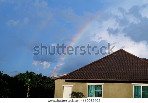 rainbow\
over the roof /bright rainbow dividing the\
sky