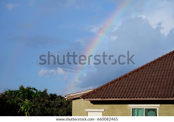 rainbow\
over the roof /bright rainbow dividing the\
sky