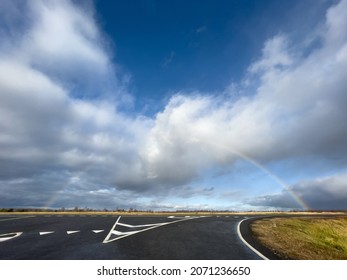  Rainbow over straight road with markings. Selective focus