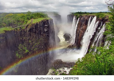 Rainbow Over Victoria Falls On Zambezi River, Border Of Zambia And Zimbabwe