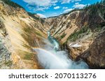 Rainbow over the waterfall. Amazing mountain landscape. Big waterfall among the beautiful rocks. Brink of  the Lower Falls on the Grand Canyon of  the Yellowstone, Yellowstone National Park, Wyoming