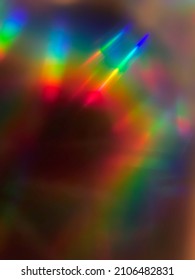 Rainbow prism streaking light rays curving through frame for background or overlay